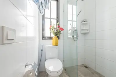 a white bathroom with a toilet and a window at Central 1 Bedroom Villa 5 Min walk to Seminyak Beach in Seminyak