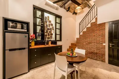 a kitchen with a table and a refrigerator at Central 1 Bedroom Villa 5 Min walk to Seminyak Beach in Seminyak