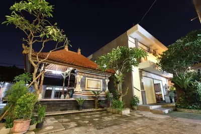 a house with trees in front of it at night at Surya Inn in Kuta