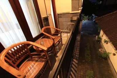 a balcony with two wooden benches and a table at Surya Inn in Kuta