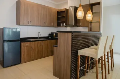 a kitchen with wooden cabinets and a stainless steel refrigerator at White Lotus Villas Seminyak in Seminyak