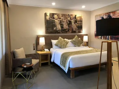 a hotel room with a bed and a tv at Puri Raja Hotel in Legian
