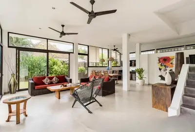 a living room filled with furniture and a ceiling fan at Villa Surga in Seminyak
