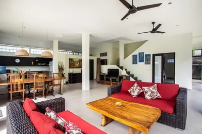 a living room with a red couch and a table at Villa Surga in Seminyak