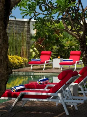 a pool with two lounge chairs and a swimming pool at Villa LeGa in Seminyak