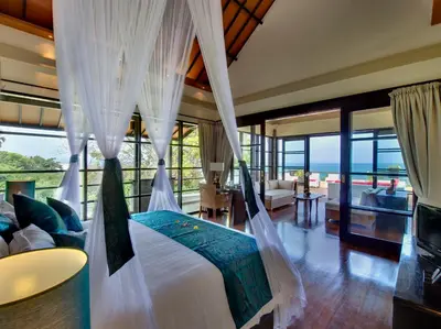 a bedroom with a bed with mosquito net at Villa LeGa in Seminyak