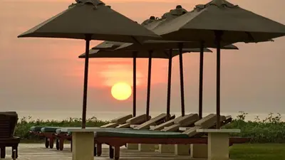 a group of chairs under umbrellas on a deck at Villa Atas Ombak in Seminyak