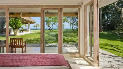 a bedroom with a bed and a view of the ocean at Villa Atas Ombak in Seminyak