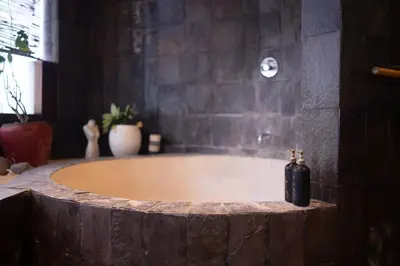 a bathroom with a bath tub with a soap dispenser at Villa Nara - Your Unique & Private Villa in Seminyak Petitenget in Seminyak
