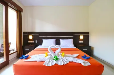 a bedroom with a bed with towels in the shape of swans at Gempita House Legian Bali in Legian