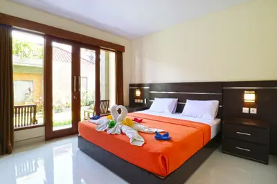 a bedroom with a bed with a stuffed animal on it at Gempita House Legian Bali in Legian