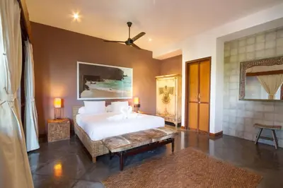 a bedroom with a large white bed and a couch at Villa Martine - Fantastic 5BR Villa - Perfect Location in Seminyak in Seminyak