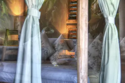 a bed with pillows and curtains in a room at Villa Layla - Charming 2BR Villa in Oberoi - Prime Location! in Seminyak