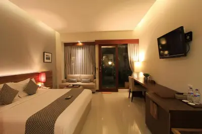a hotel room with a bed and a desk and a television at Uma Karan in Seminyak
