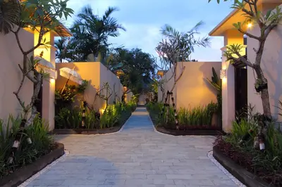 a walkway between two buildings with palm trees at RC Villas and Spa Bali in Seminyak