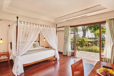 a bedroom with a bed with a canopy at Villas at The Patra Bali Resort and Villas - CHSE Certified in Kuta
