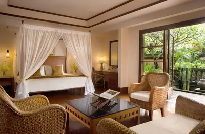 a hotel room with a bed and a table and chairs at Villas at The Patra Bali Resort and Villas - CHSE Certified in Kuta