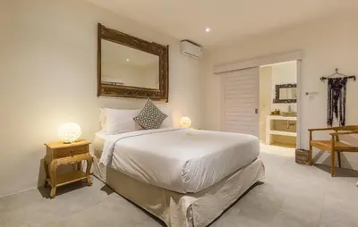 a bedroom with a bed with a mirror and a table at Villa soul in Seminyak