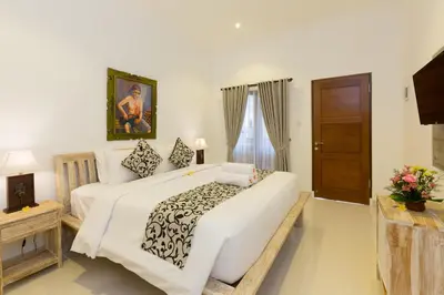 a bedroom with a large white bed and a window at Amerta Seminyak in Seminyak