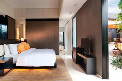 a bedroom with a white bed and a television at W Bali - Seminyak in Seminyak