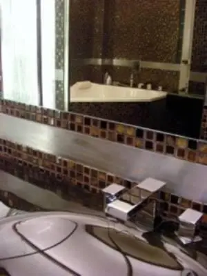 a bathroom with a sink and a mirror at Sejuk Suites in Legian