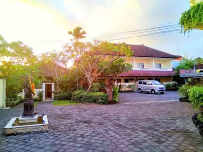 a house with a car parked in front of a driveway at Nipuri Resort and Villas Seminyak by Kamara in Seminyak