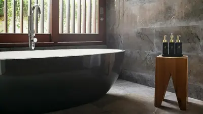 a bathroom with a bath tub and a sink at Villa Indrani in Canggu
