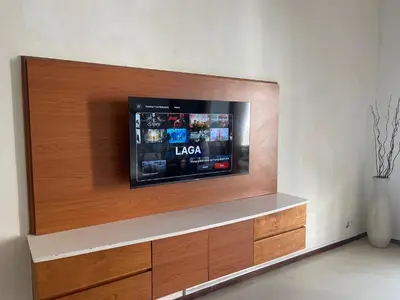a flat screen tv mounted on a wall at Balcony Living Apartment in Seminyak