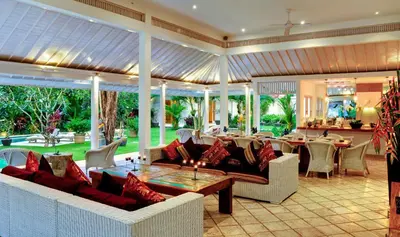 a living room with couches and a table and chairs at Villa Sipo in Seminyak