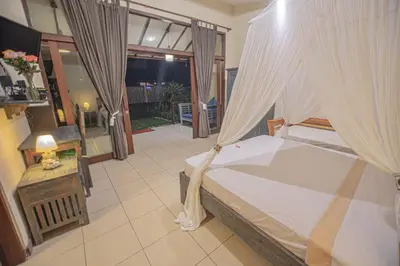 a bedroom with a bed with curtains and a table at Sasa Bali Villas in Seminyak
