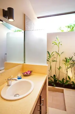 a bathroom with a sink and a wall with a painting at Sasa Bali Villas in Seminyak