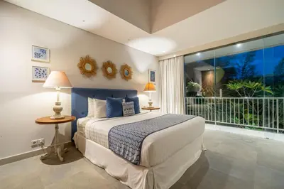 a bedroom with a bed and a large window at Villa Jekumah 2 in Seminyak