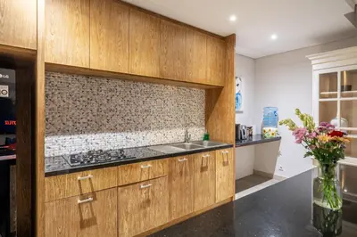 a kitchen with wooden cabinets and a counter top at Villa Jekumah 2 in Seminyak
