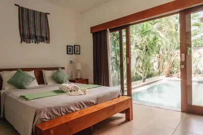 a bedroom with a bed and a swimming pool at Charming Private Villa with Pool in Canggu