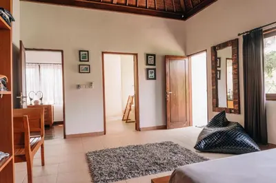 a room with a bedroom with a bed and a table at Charming Private Villa with Pool in Canggu