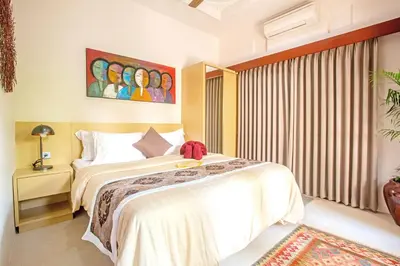a bedroom with a large bed and a window at Villa Ellen in Seminyak