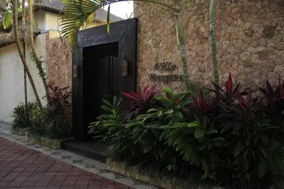 a black door in the side of a building with plants at Villa Margaux in Seminyak