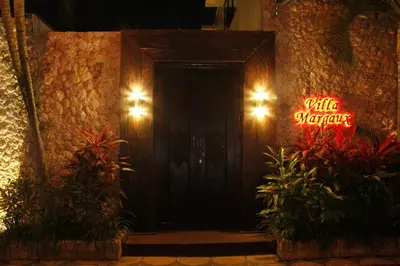 a black door with a neon sign that reads public warehouse at Villa Margaux in Seminyak