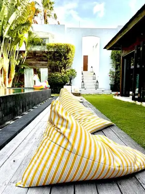 a group of yellow and white striped blankets on a wooden table at Elegant Villa Casabianca - Tropical Pool & Garden, Near Potato Head Beach Club! in Seminyak