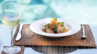 a bowl of food on a table with a glass of wine at Casa Brio in Seminyak