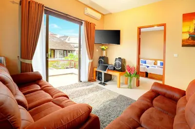 a living room with a couch and a television at Villa Alessandra Seminyak By Bali Asia Villa in Seminyak
