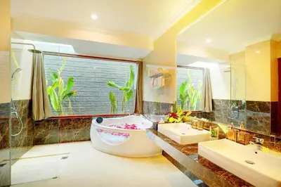 a bathroom with a tub and two sinks and a window at Villa Alessandra Seminyak By Bali Asia Villa in Seminyak