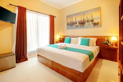 a bedroom with a large bed and a window at Villa Alessandra Seminyak By Bali Asia Villa in Seminyak