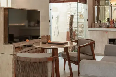 a living room with a table and chairs and a tv at La Vie Villa Seminyak by Ini Vie Hospitality in Seminyak