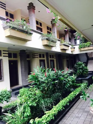 a courtyard of a building with plants and flowers at Tanjung Sari Inn in Nusa Dua