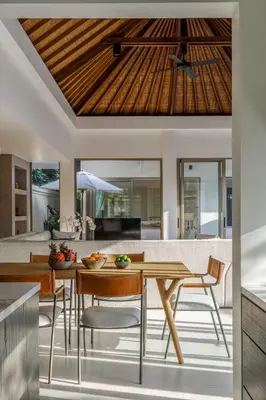 an open kitchen and dining room with a wooden ceiling at Villa Ria Bali in Seminyak