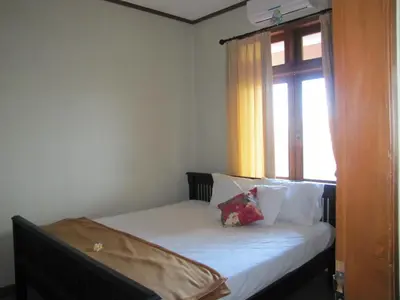 a bed in a room with a window at Diva House in Denpasar