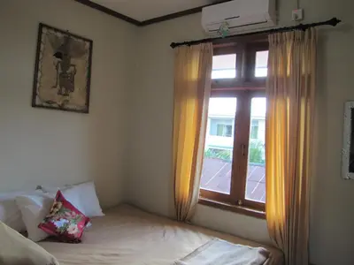 a bedroom with a bed and a window with at Diva House in Denpasar