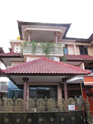 a building with a red roof and a balcony at Diva House in Denpasar