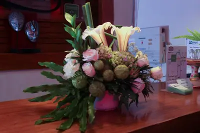 a bouquet of flowers in a vase on a table at The Green Zhurga Suite Seminyak in Kerobokan